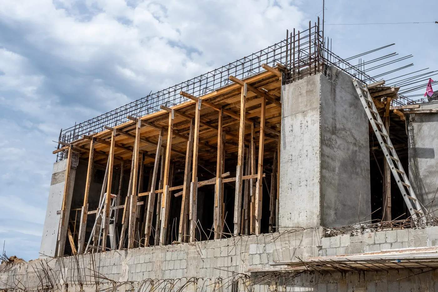 Concrete frame under construction with timber formwork and props holding the upper slab and exposed rebar, Casa Querencia 32 in Los Cabos