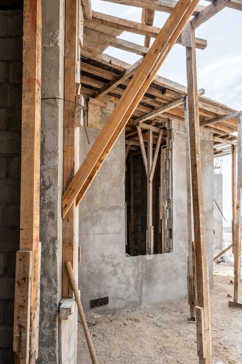 Interior opening framed by timber props and formwork beams against a block wall during construction