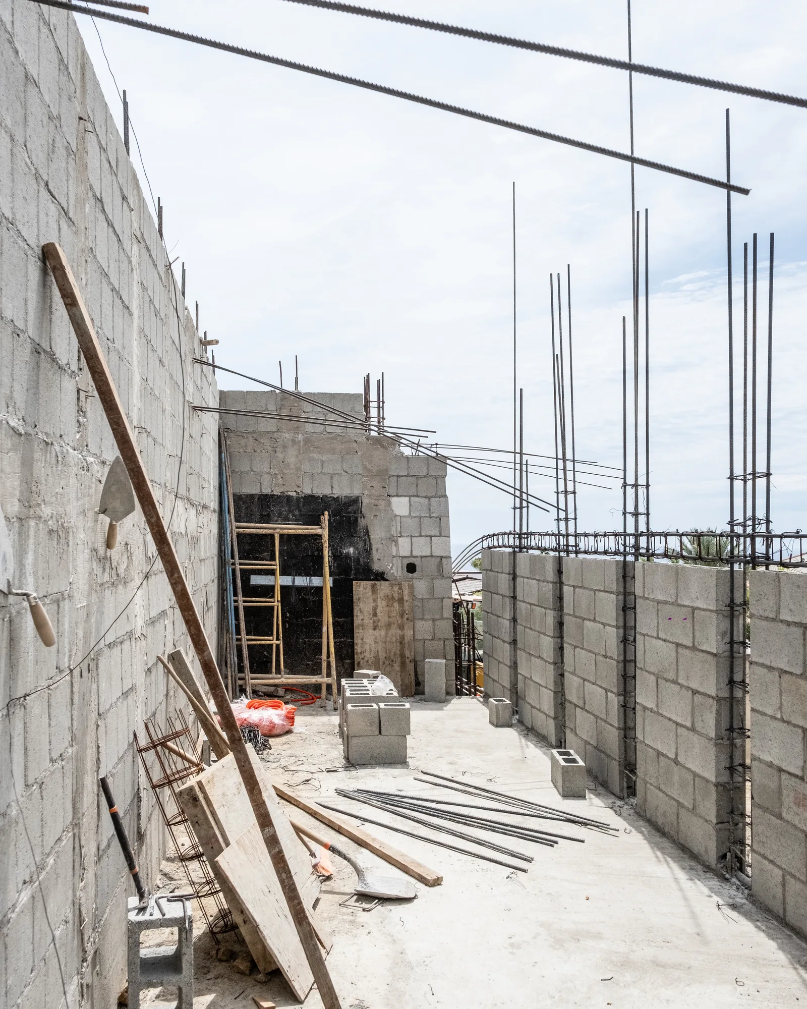 Rooftop level between block walls with a field of vertical rebar dowels ready for the next pour