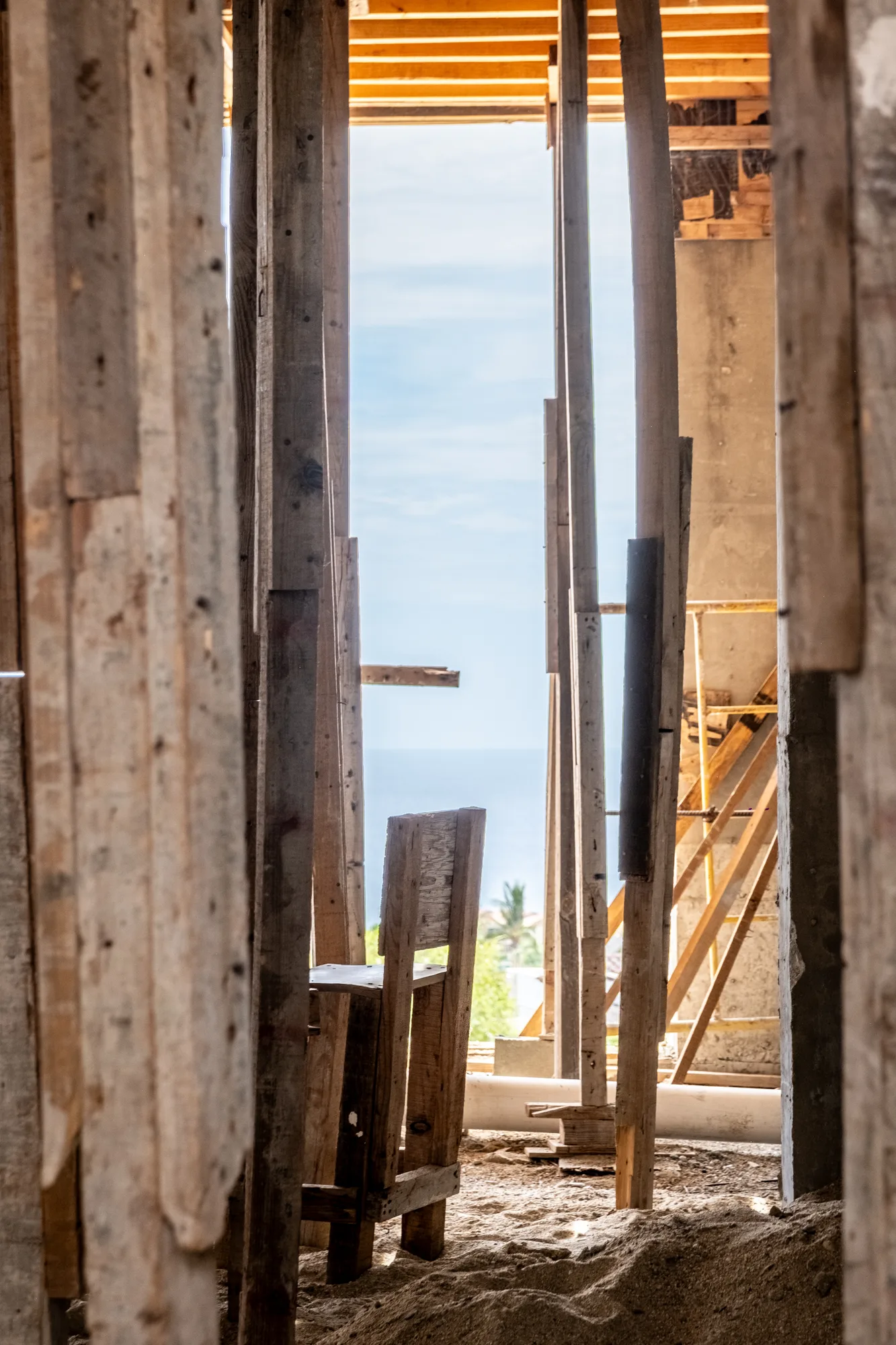 Sea view framed through the narrow gap between timber formwork planks on site