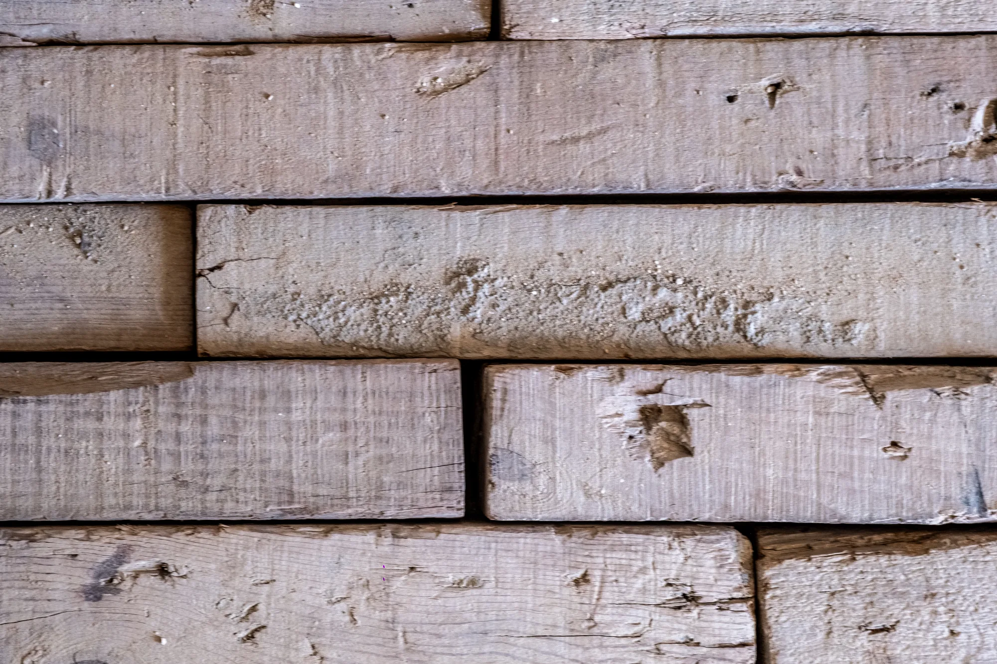 Close-up of the rough-sawn timber formwork planks marked with concrete, a study of material and texture